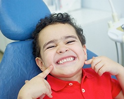 A boy smiling in a dental chair