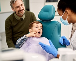 A young boy pointing out his toothache to a dentist