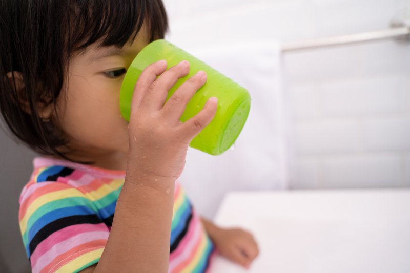 Child with good dental health sipping from a cup