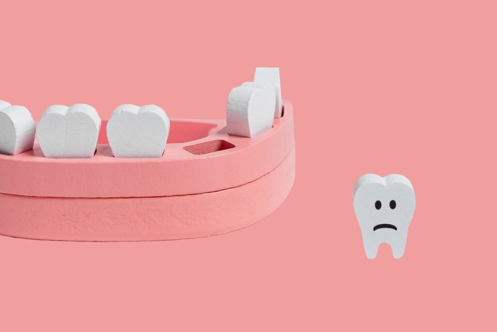 A sad wooden tooth separated from the other model teeth